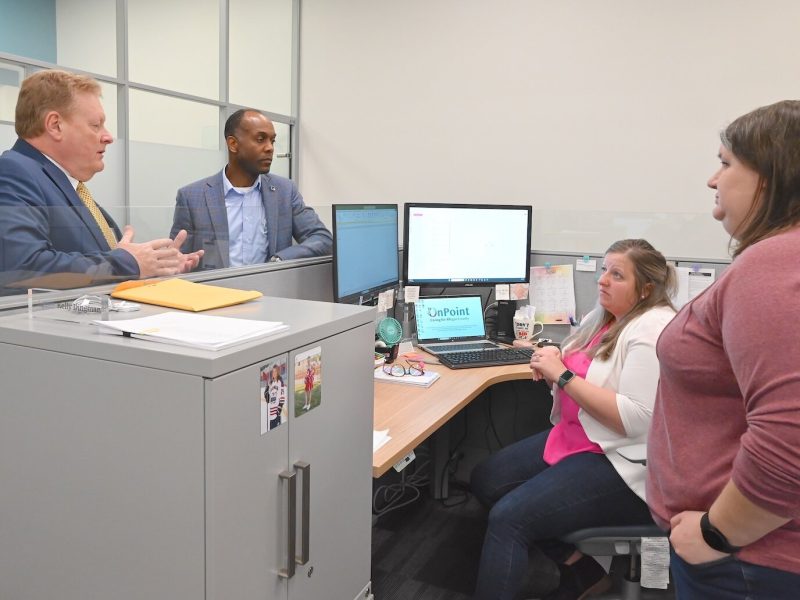 Mark Witte chats with OnPoint staff: from left,  Andre Pierre, Jr., chief administrative officer; Kelly Dingman, accounting supervisor, and Sarah Lumbert, general accountant.