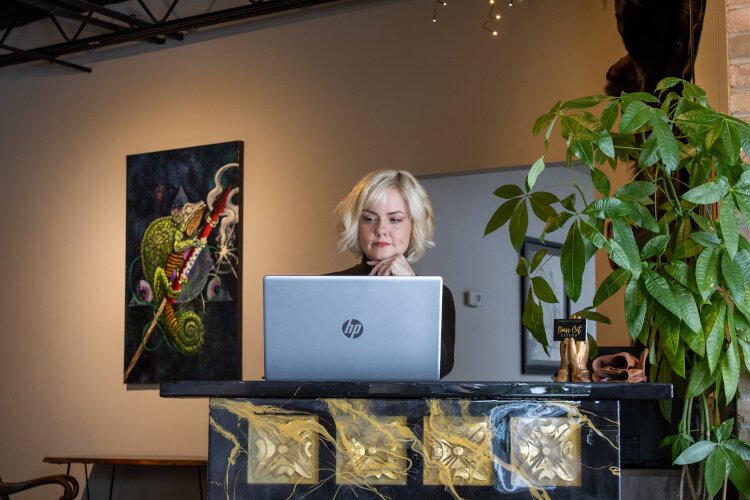 Co-owner Angel Black working in the waiting area during a tattoo appointment at Brass Cat tattoo Studio