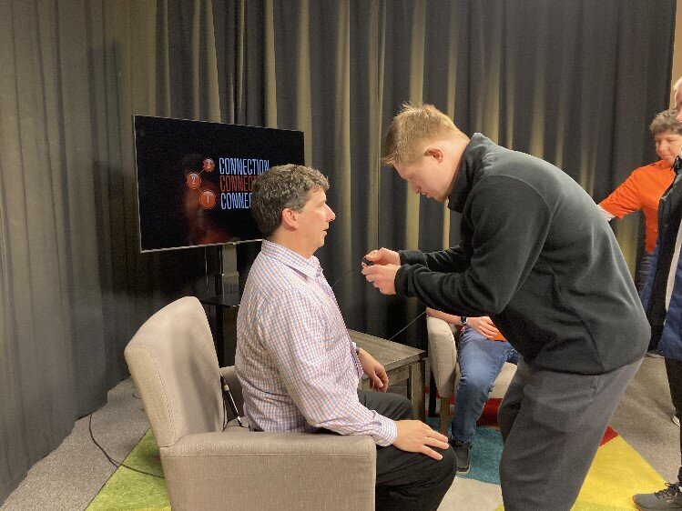 Adam White places a mic on Kevin Heye