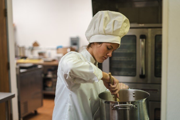 Ava Root stirring the pot.