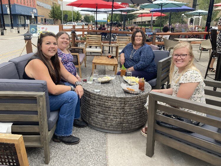 Customers enjoying the new outdoor furniture at Three Bridges Distillery in downtown Midland.