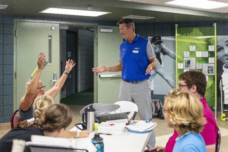 Greater Midland Tennis Center Executive Director Jeff Rekeweg chats with participants in a  tennis camp.