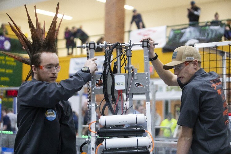 Team members of "Circuits of Destruction" of Merrill High School remove their robot from the field during the FIRST.