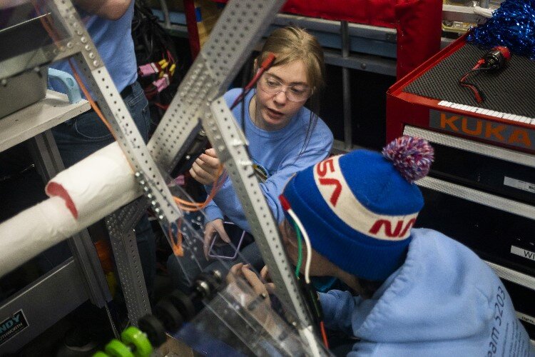 Meridian junior Hannah Capitana, center, and senior Luciano Tanzini, right, team members of "Volatile Chaos Inhibitors" of Meridian Early College High School, work on their robot.