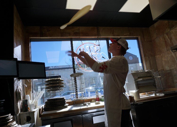 Landen Wray tosses Pizza Sam’s homemade crust. The crust recipe hasn’t changed since the restaurant opened 63 years ago.