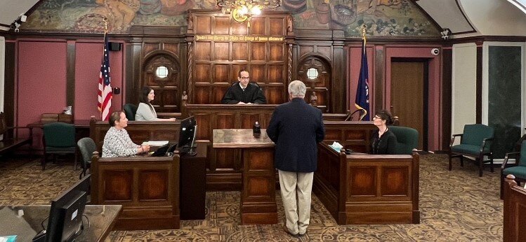 42nd Circuit Court Judge Stephen Carras and staff in courtroom.