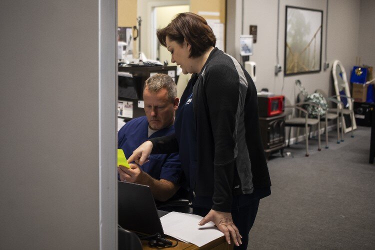 Adrienne Schmitt, right, confers with PA (physician assistant) John Roberts.