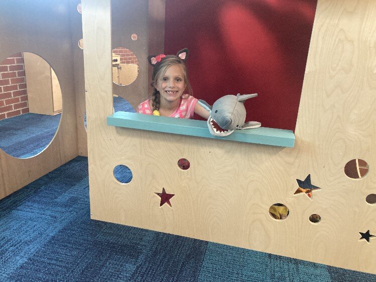 Mivra Saul, 7, and a shark in one of several play stations in Youth Services where flood damage was extensive.