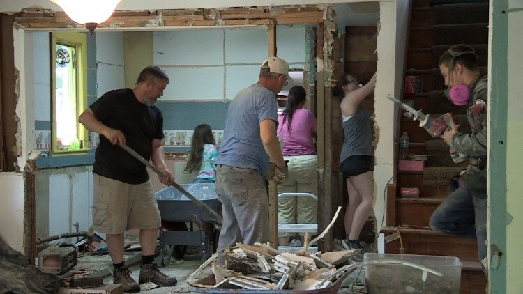 A volunteer crew helps the owners clean out a Midland home.