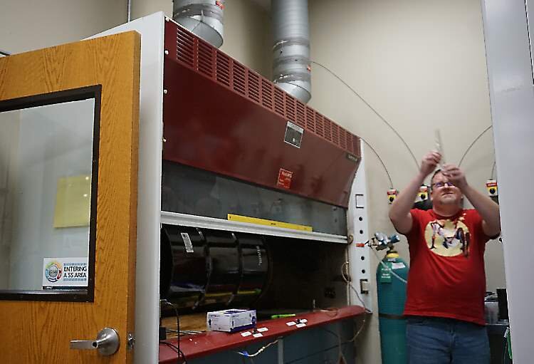 There’s a reason the walls inside this fume hood are black — this is where all the flammability testing is done.