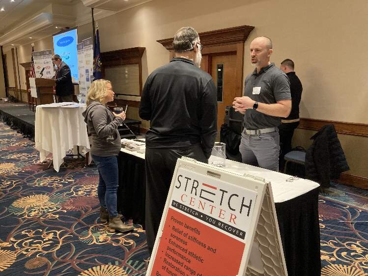 Jeff Berard, owner of the new Stretch Center, explains his clinics’ services to an attendee at Friday’s event. 