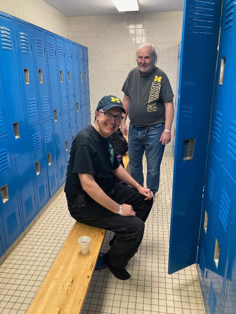 Mike Walker (seated) and Ron Wellman get ready for aquatics class in the Oasis Pool locker room.