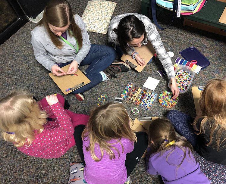 Children work on projects together, like this beading circle, to help cope with the loss of someone they know who has died.