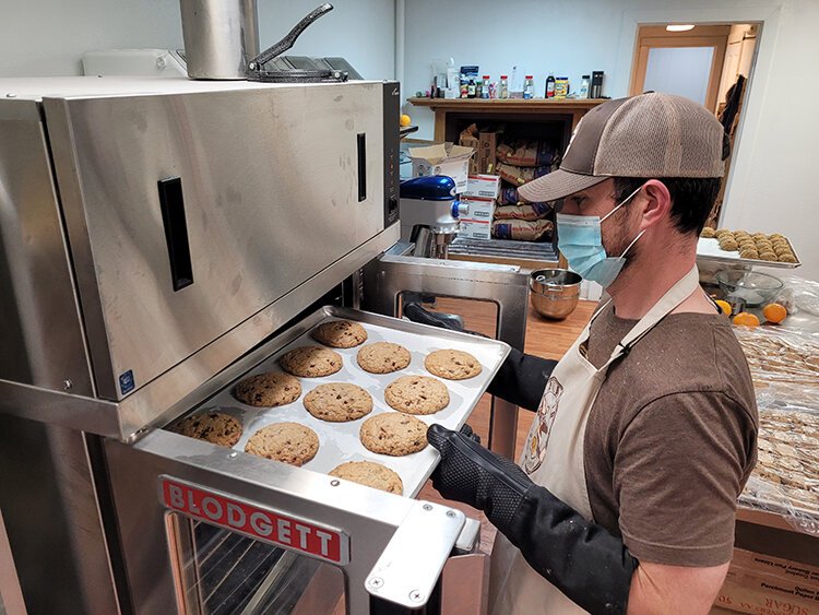 Chris Welch removes Aviator Cookies from oven.