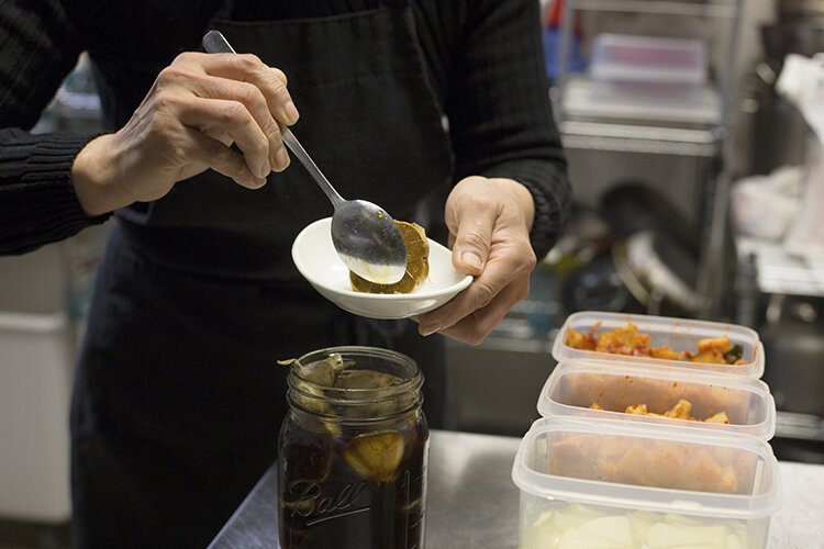 Owner of Jib-Bob Korean Restaurant Maya Denflow plates a side order of handmade pickled garlic. "Jib-Bob means mother's homemade food," says Denflow. "That's how I want to serve my customers...that's how I care."