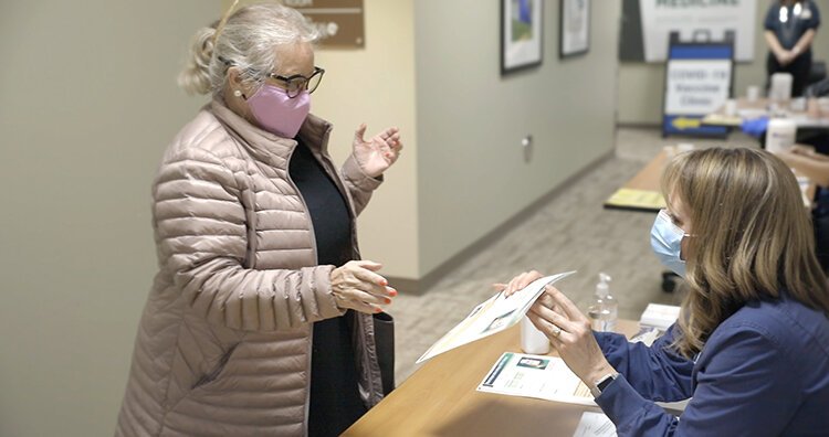 Sanford resident, Denise Drake, reviews COVID-19 information with Michelle Abedrabo, R.N., data specialist II, prior to her vaccination.