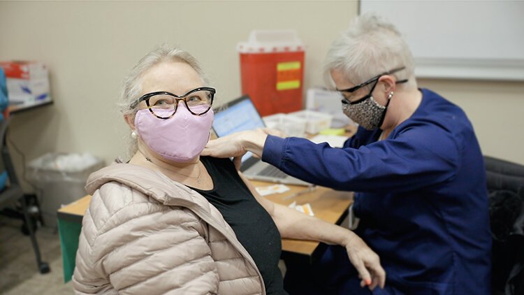 Mary Wideman, R.N., administers the COVID-19 vaccine to Sanford resident Denise Drake.