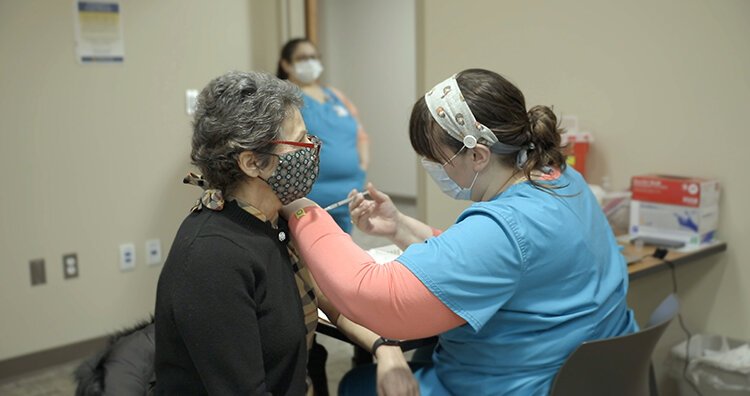 Melanie Kalmar, of Midland, receives her vaccine from Samantha Osburn, medical assistant.
