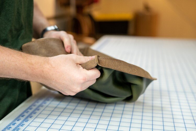 Dietlein turning a tote bag to the finished product. Tote bags are sewn inside out.
