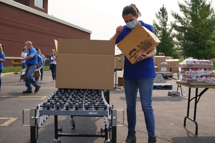 A Corteva employee packs food on a conveyor belt.