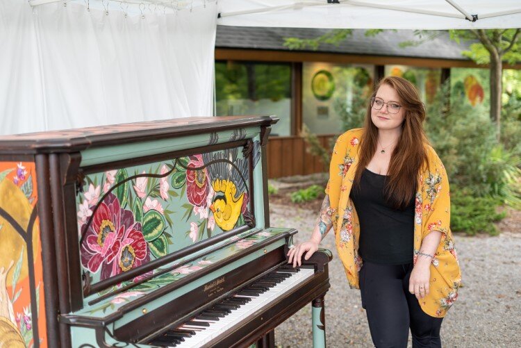 Artist Jordan Switala by her piano at Dahlia Hill.
