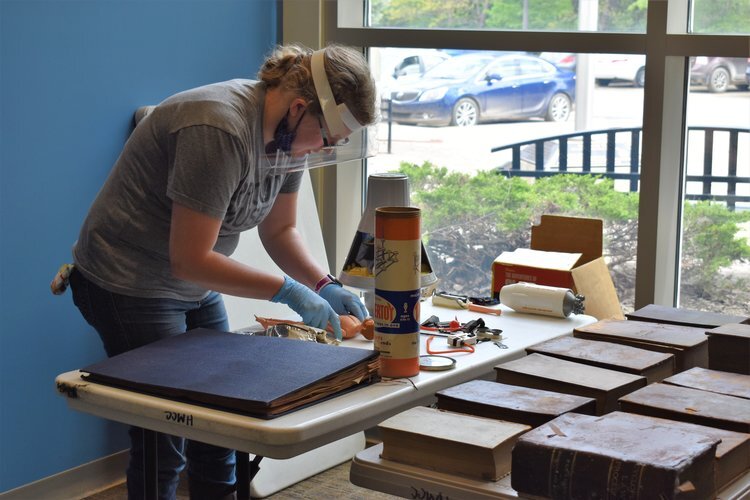 A volunteer carefully tends to recovered materials.