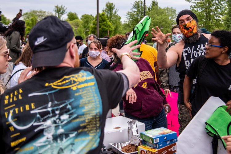 Organizer Steven Green throws a vest to John Campbell, who volunteered as a peace moderator for an event to protest the death of George Floyd and social injustice. (PC: Isaac Ritchey)