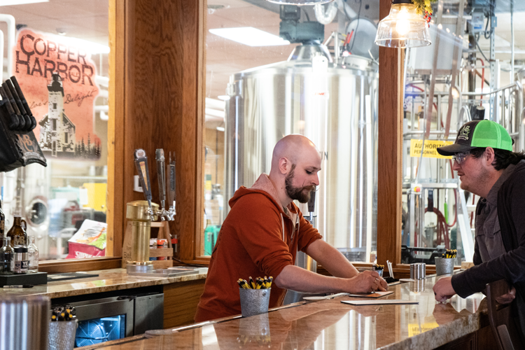 Sanborn and another employee discuss tasting notes of a beer.