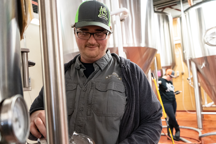 Kyle Sanborn, head production manager at Midland Brewing Company, pours to test a beer in the works.