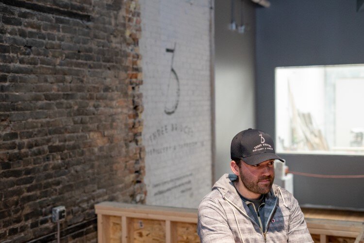 Behind Thurow is the building's original front window, which was repurposed as the distillery room window.