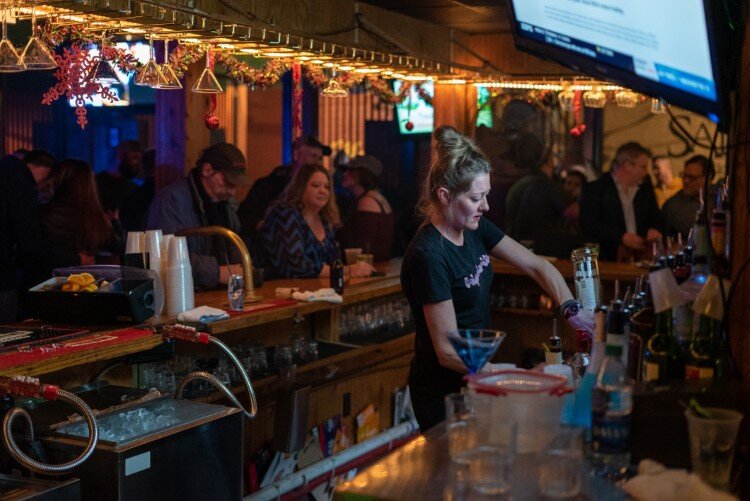 A bartender serves up drinks at Stables