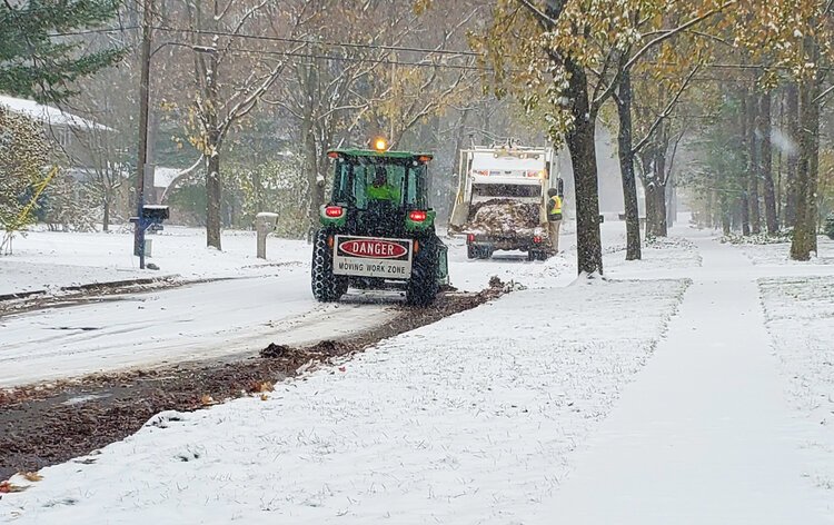 Snow often makes leaf collection more challenging for workers.