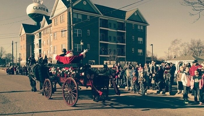 Santa greets community members from a horse drawn carriage as he rides down the streets of downtown for Christmas in Clare. Photo courtesy of the Clare Area Chamber of Commerce.