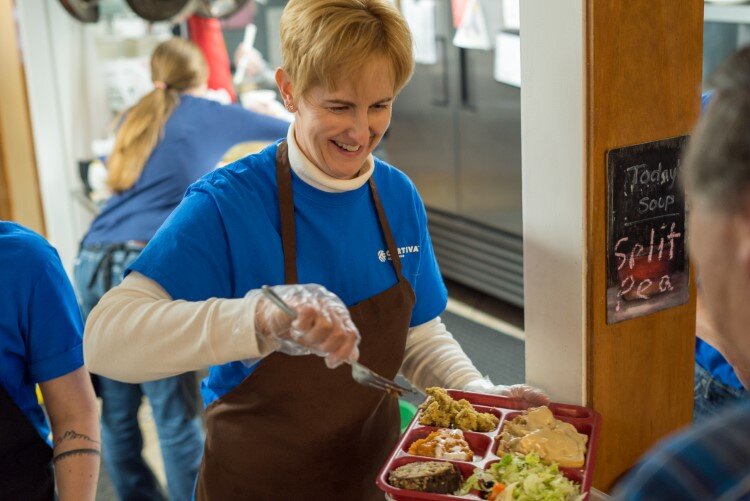 A volunteer serves up lunch in Open Door’s soup kitchen.