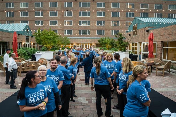 Volunteers line up to serve all guests at once.
