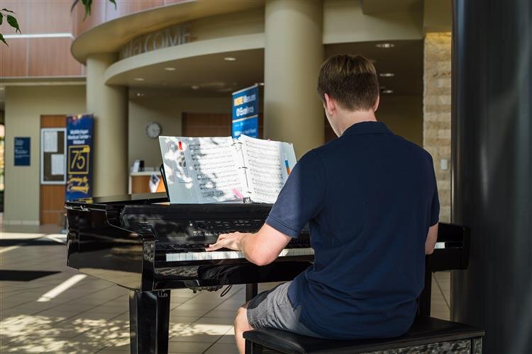 Joseph Jackson, a junior at H.H. Dow High School performs in the lobby.