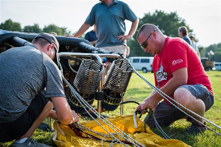 A team prepares equipment prior to a morning flight.
