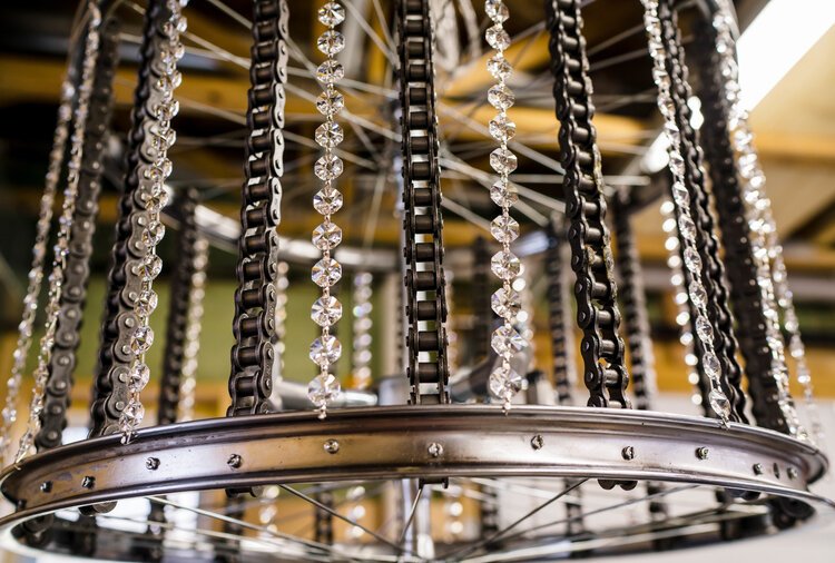 One of Acosta's bike rim and chain chandeliers in his workshop.
