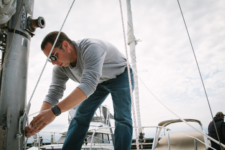 Anthony DeGraw making final tie downs after a sail in Tawas Bay.