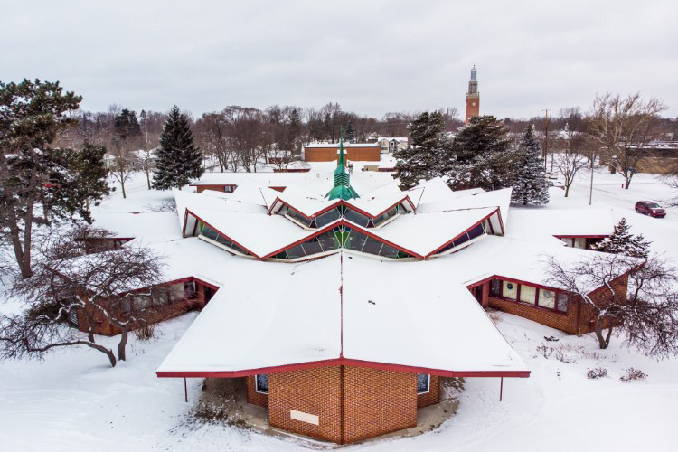 The church is marked by a broken roof line and copper spire.