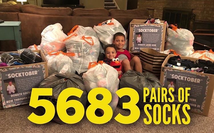 Jaxon and his brother proudly piled in the heap of socks donated.