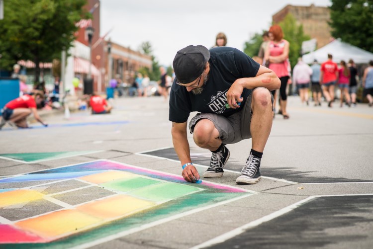 An artist works on his submission for Bay City’s summer Chalk Art Festival in 2018.