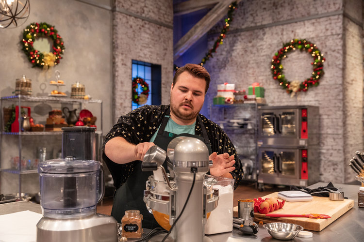 Schooled pushes through the timed baking challenge on set with the Food Network.