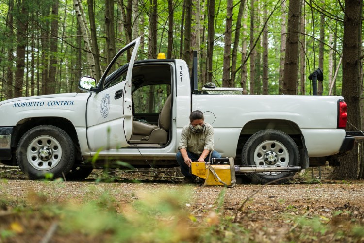 Kimberly Tozier, a staff member at Midland County Mosquito Control gets ready to spray an area of standing water.