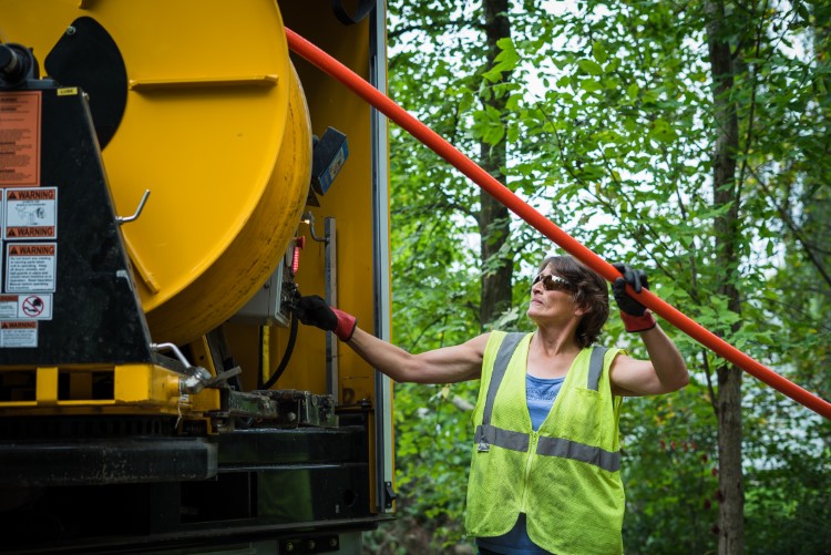 Christensen feeds hose from the water treatment truck as part of routine maintenance.