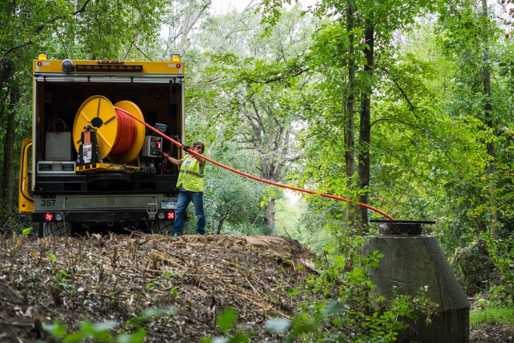 Christensen in the woods doing maintenance on a drain pipe.