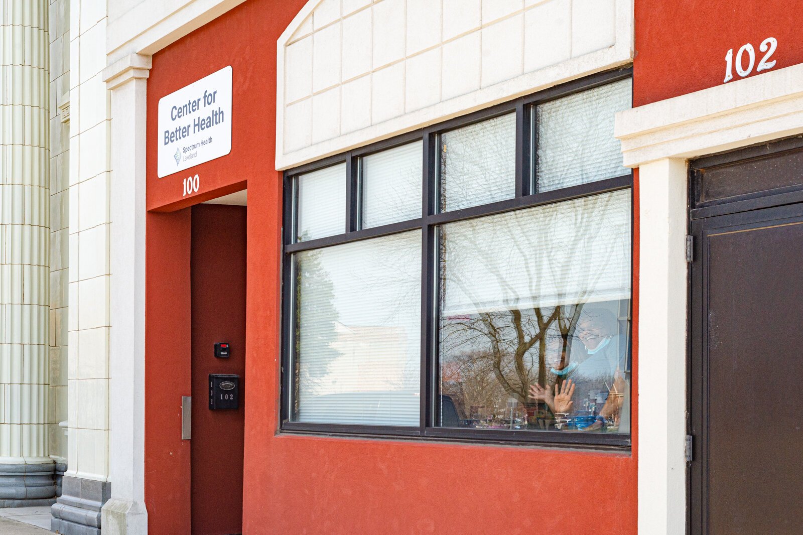 Staff wave from inside the Center for Better Health and Wellness.