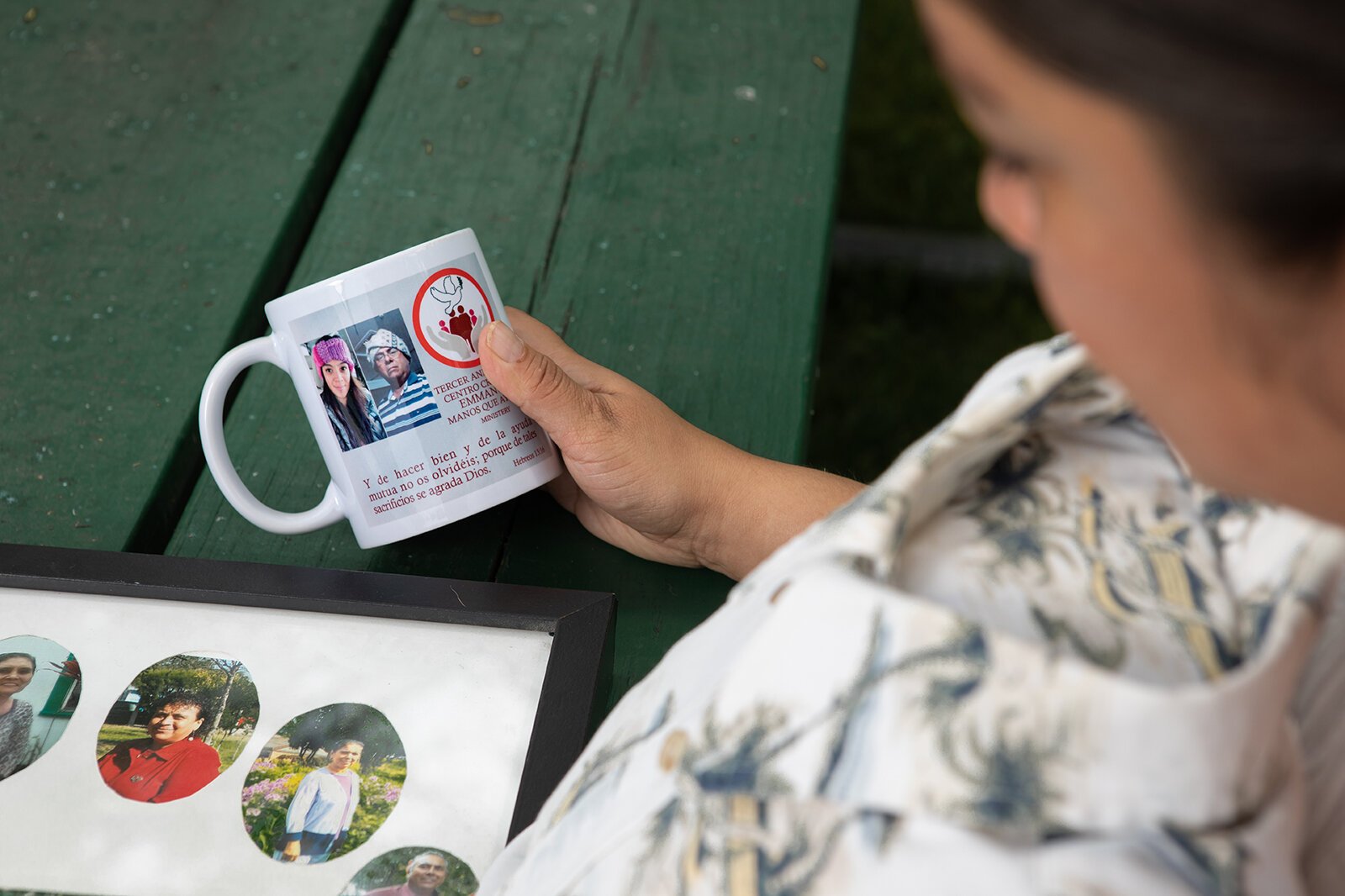 Isabel Romero holds a mug bearing a photo of her uncle, who died of COVID-19.