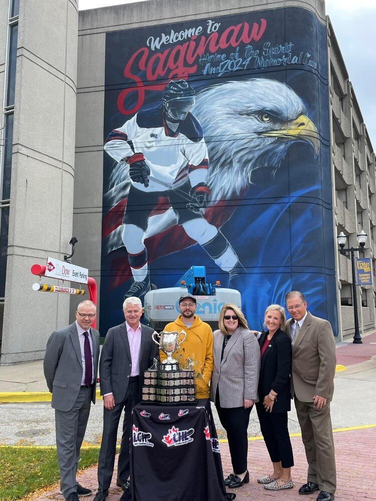 Leaders of the effort to bring one of hockey's bigger events pose with the Memorial Cup.