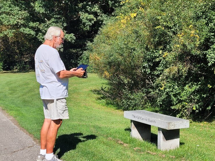 Community volunteer Jim Malek documents location of memorial bench at Currie Golf Course.